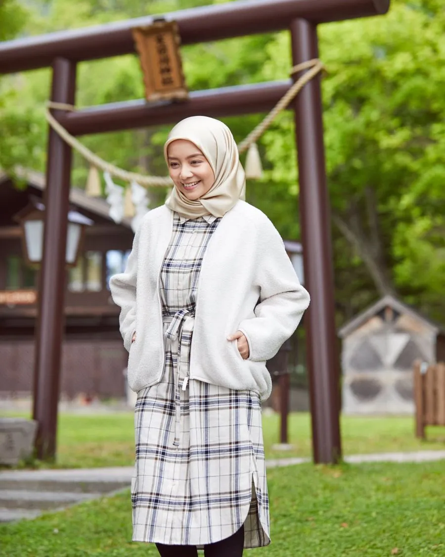 A Muslim woman in a white cardigan