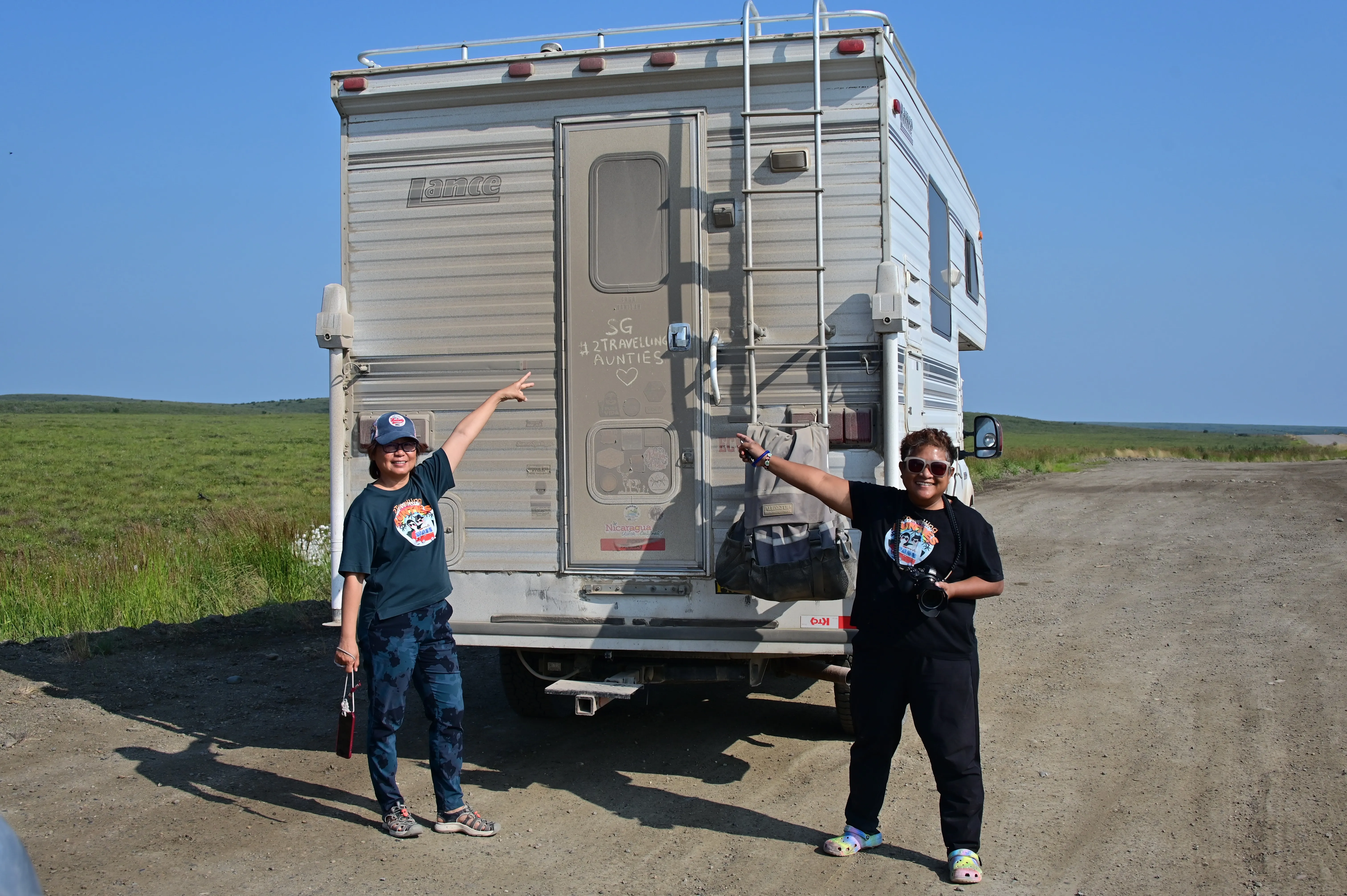 Two women infront of a truck with their name on it