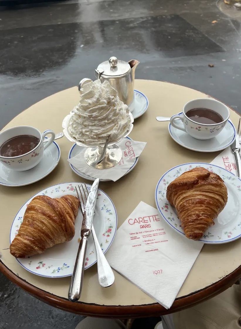 croissants and hot chocolate with whipped cream in the center of the table