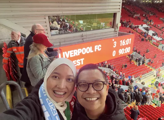 Man and woman posing in a football stadium