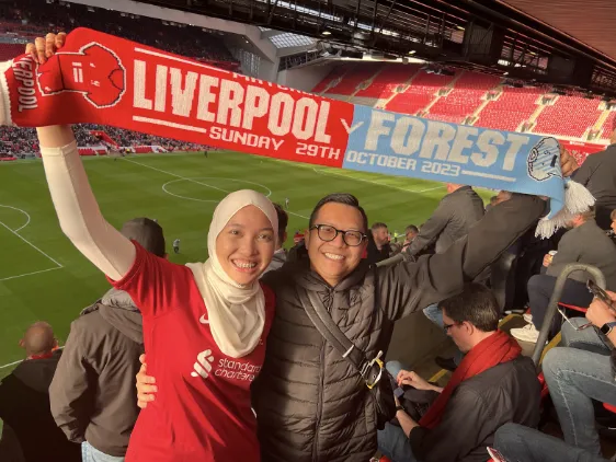 Man and woman holding up a football banner