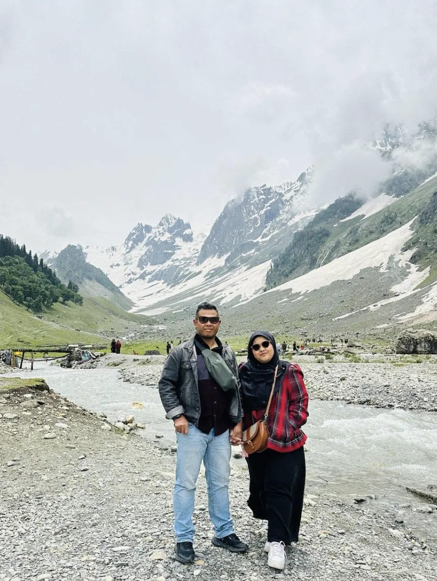 A couple standing infront of a glacier