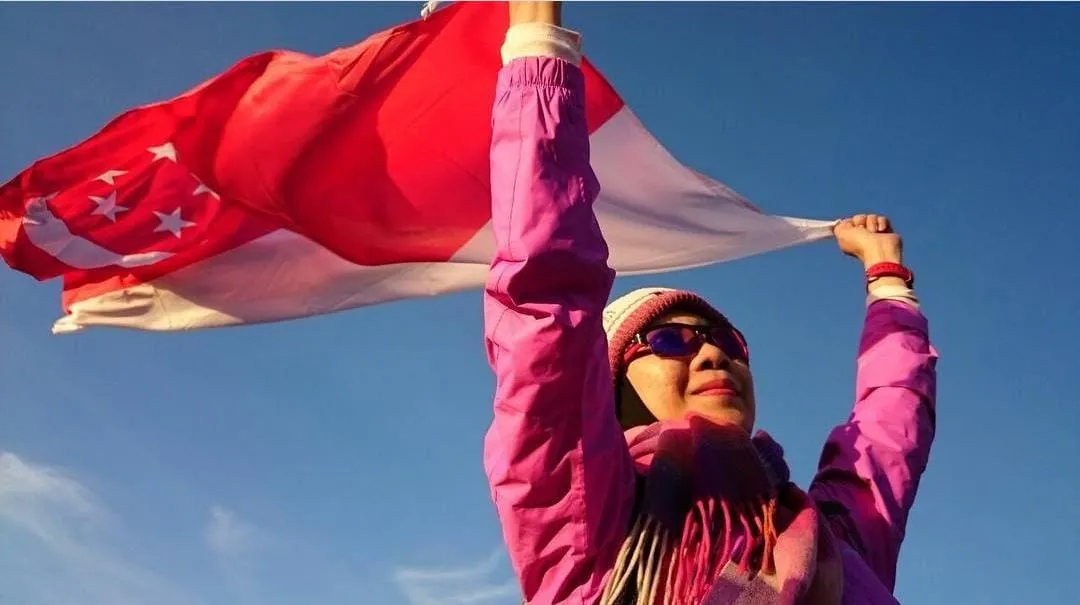 a woman holding the singapore flag